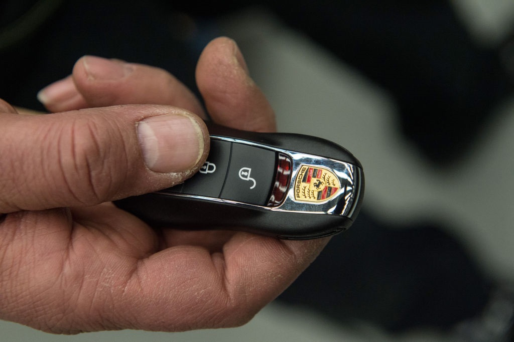 An employee is holding the keys of a Porsche 918 S