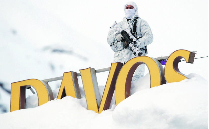 SNOW PATROL A Swiss police officer observes the surrounding area from atop the roof of the Davos Congress Hotel ahead of the World Economic Forum’s annual meeting in Davos, Switzerland. Picture: Reuters 