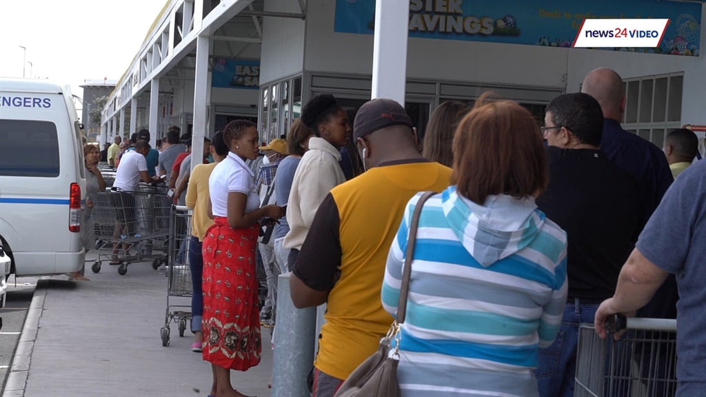 Capetonians wait outside Makro in queues as the store only allows in 50 people at a time to do their shopping. 