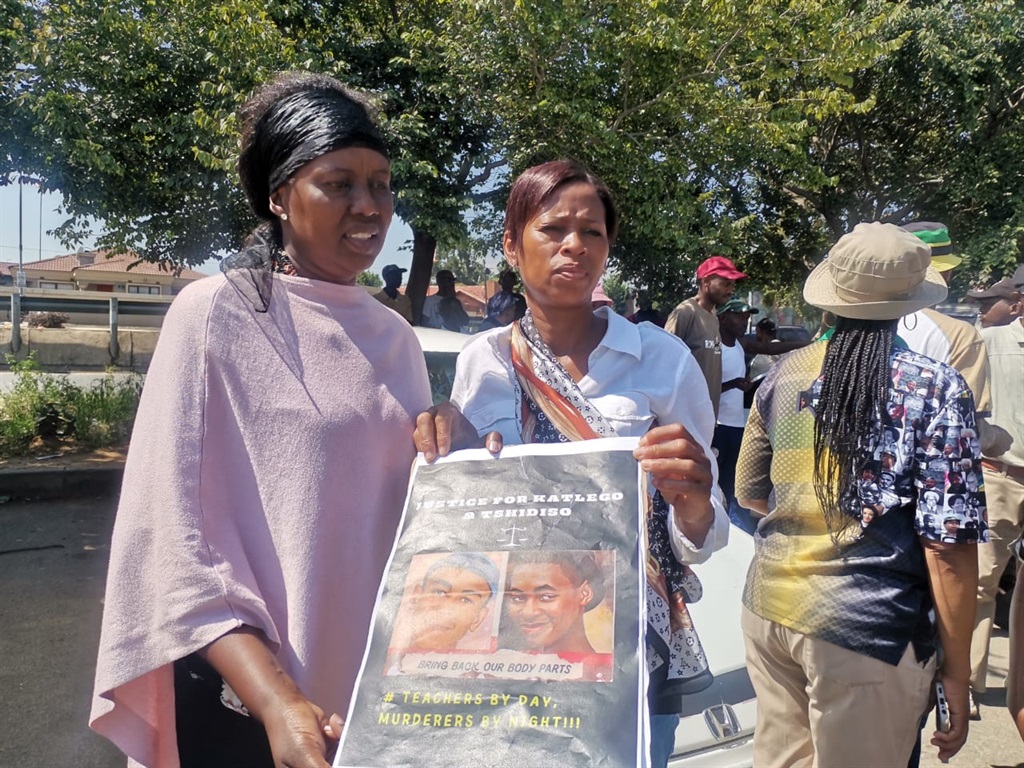 From left: Aunt Charmaine Letsheli and mum Petunia Letsheli holding a picture of two of the three young men who were murdered allegedly by a teacher. Photo by Emily Mgidi