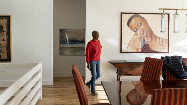 B. Smith passes a portrait of herself by the artist Sid Daniels as she walks in her East Hampton home on Long Island