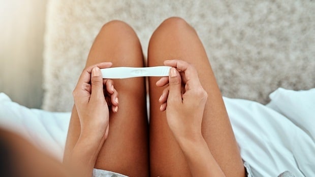 Cropped shot of a young woman taking a home pregnancy test