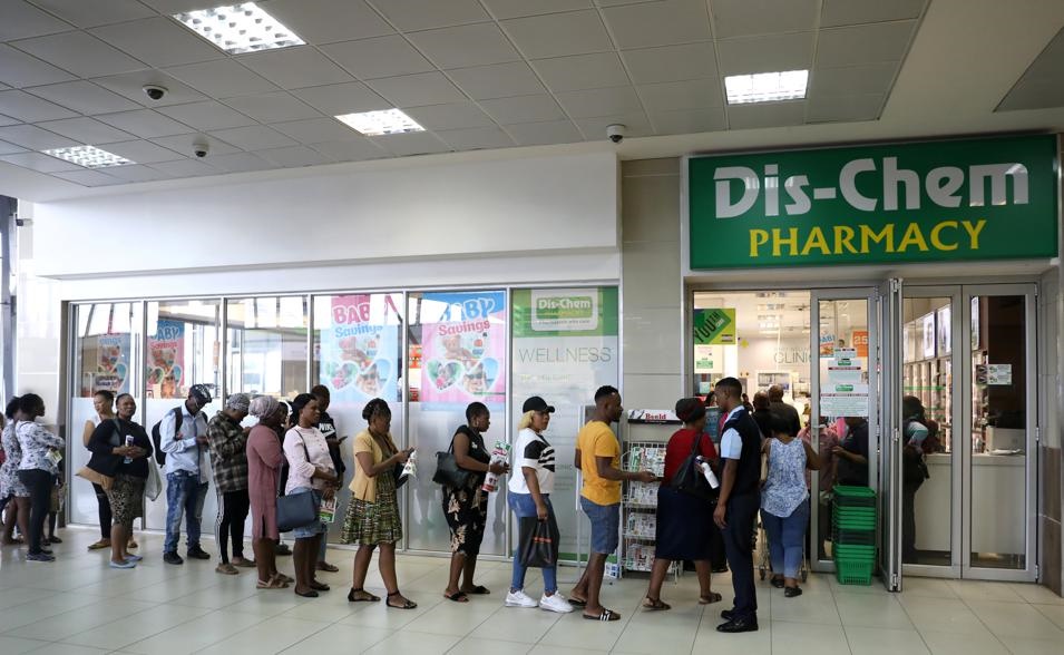 Shoppers queue outside Dis-Chem Pharmacy ahead of a nationwide lockdown for 21 days to try to contain the Covid-19 coronavirus  outbreak. Picture: Siphiwe Sibeko/Reuters 
