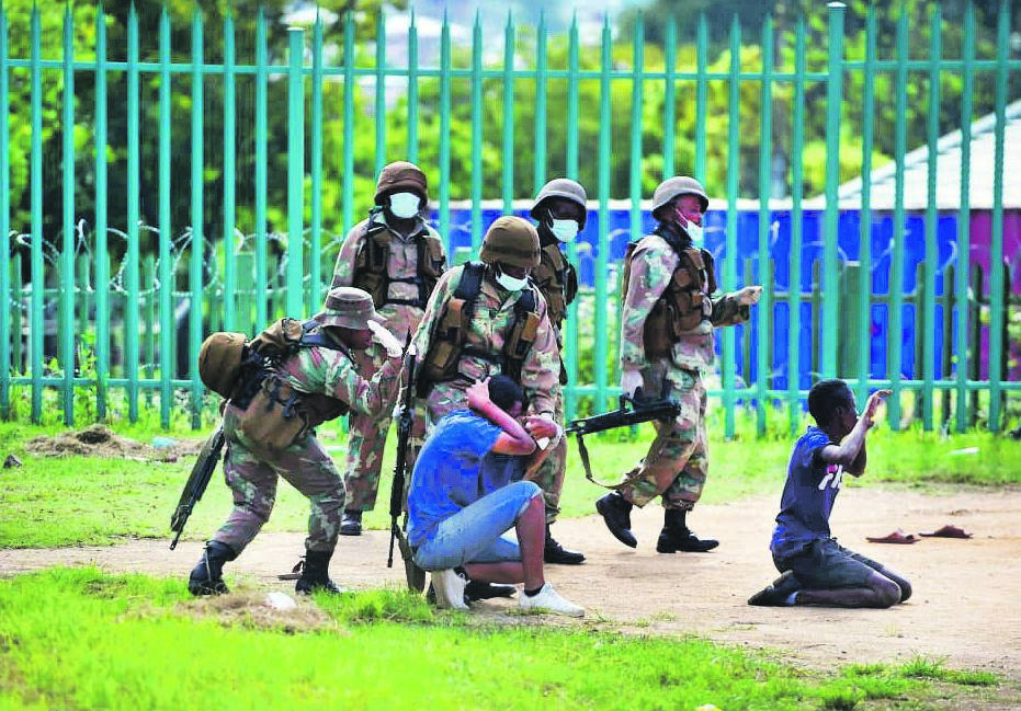 In Alexandra township, members of the SA National Defence Force restrain two men who had been flouting the regulations of the 21-day   Covid-19 coronavirus lockdown. The defence force has came under fire for being heavy-handed on defiant citizens. Picture: Trevor Kunene