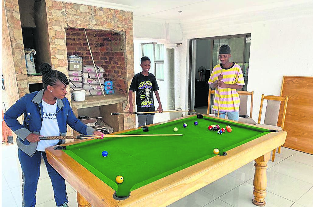 Winnie Seloba enjoys a game of pool with her sons at home in Limpopo.