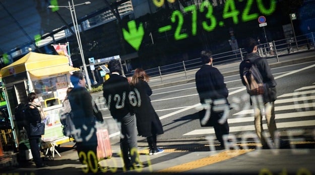 Pedestrians are reflected in an electronic stock board outside a securities firm in Tokyo, Japan, on Tuesday, Feb. 6, 2018. Photographer: Noriko Hayashi/Bloomberg