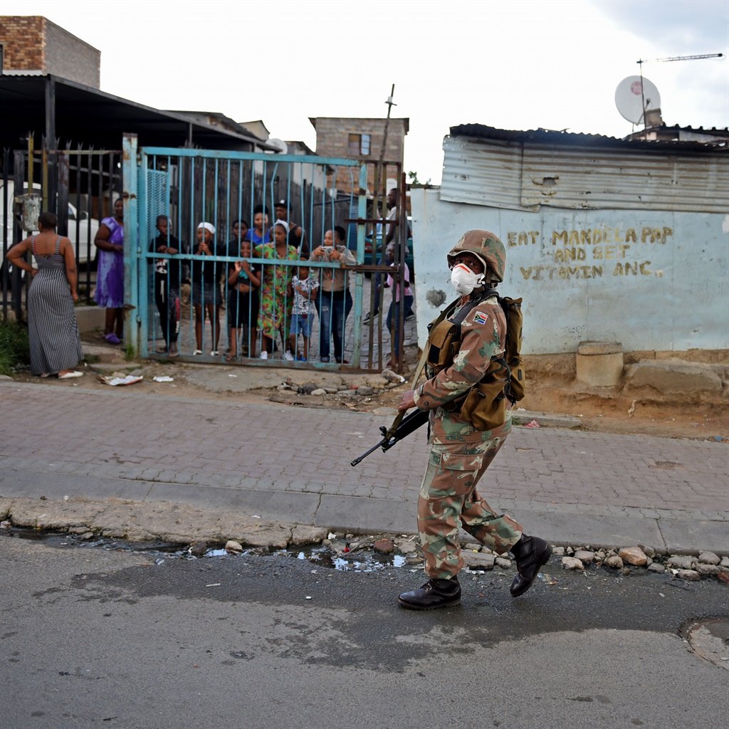 SANDF members were boots on the ground as residents of Alexandra kept their distance but let their curiosity run wild as they obseved the soldiers in full gear. Picture: Tebogo Letsie