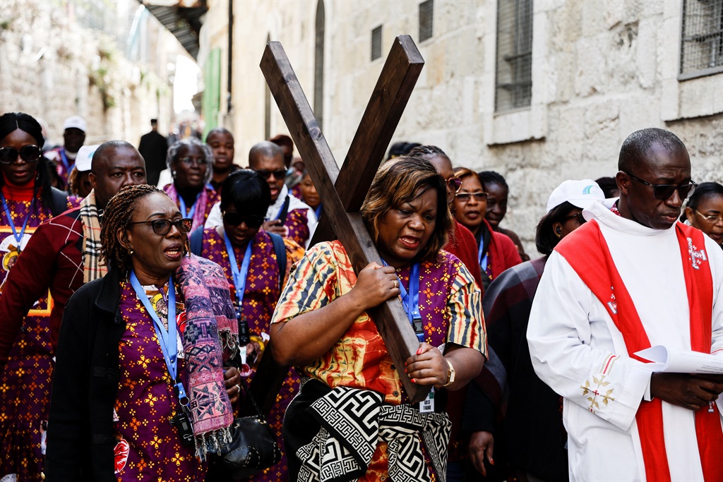 Worshippers carry a cross as they take part in the