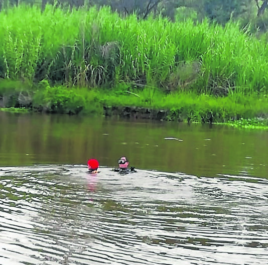 Police divers retrieve the body of a man who drowned while fishing in the Crocodile River on Friday. 