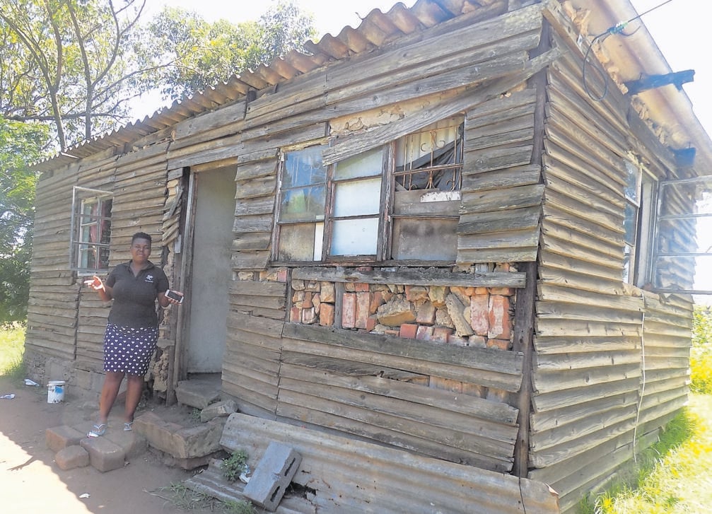 Lethiwe Vilakazi outside the rundown house she shares with her family. Photo by Mbali Dlungwana