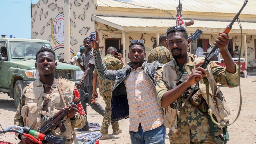 Sudanese army soldiers posing with guns at enemy b