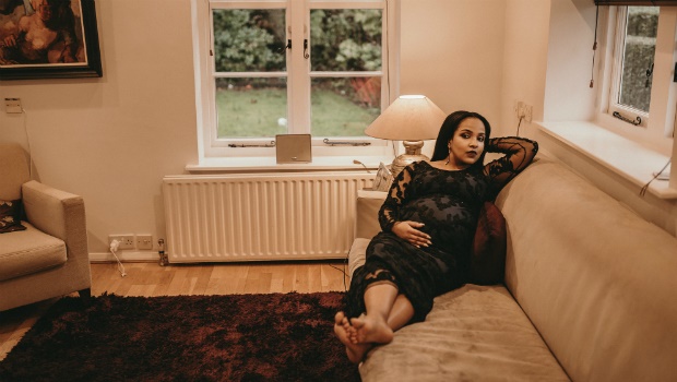 A pregnant woman relaxes on the couch
