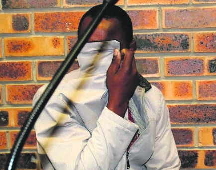 Alleged serial killer Julius Mndawe covered his face with a jacket in the Masoyi Periodical Court on Friday.      Photo by Bulelwa Ginindza
