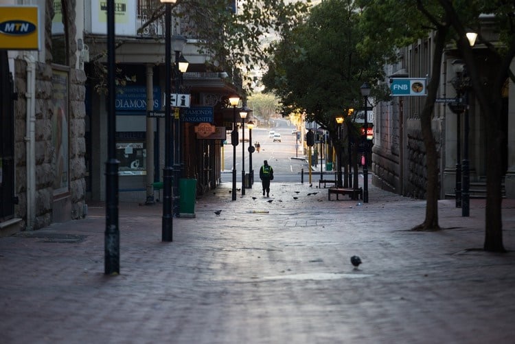 A security guard patrols an otherwise empty street on day one of the lockdown. (Ashraf Hendricks, GroundUp)