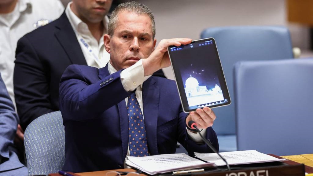 Israeli Ambassador to the UN Gilad Erdan shows a video of drones and missiles heading toward Israel during a United Nations Security Council meeting on the situation in the Middle East, including Iran's recent attack against Israel, at UN headquarters in New York City. (Charly Triballeau/AFP)