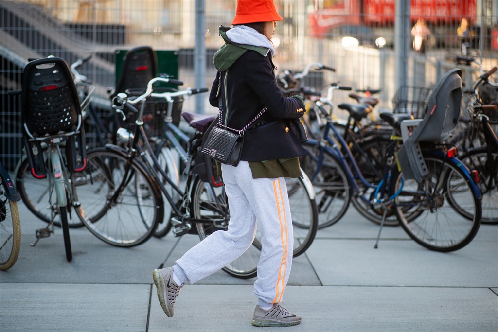 A guest is seen wearing jogger pants, sneaker, orange bucket hat, Chanel bag outside Resume during the Copenhagen Fashion Week Autumn/Winter 2019