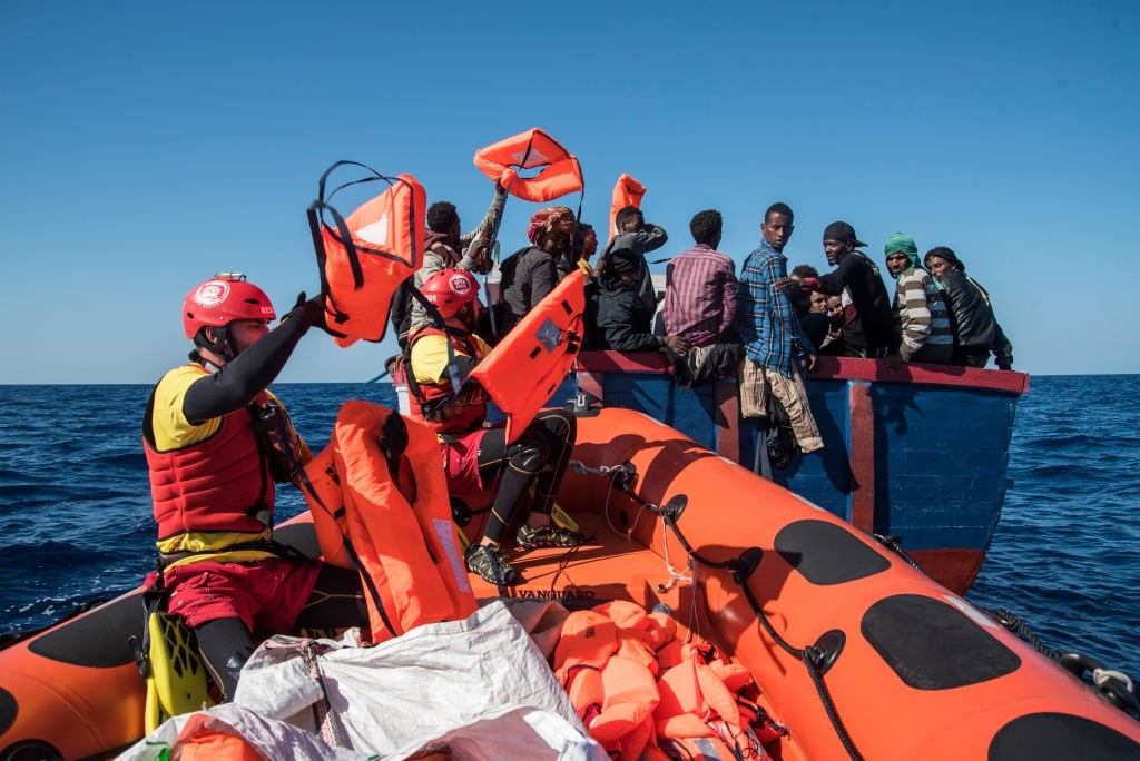 Migrants seen waiting to be rescued from their boat.