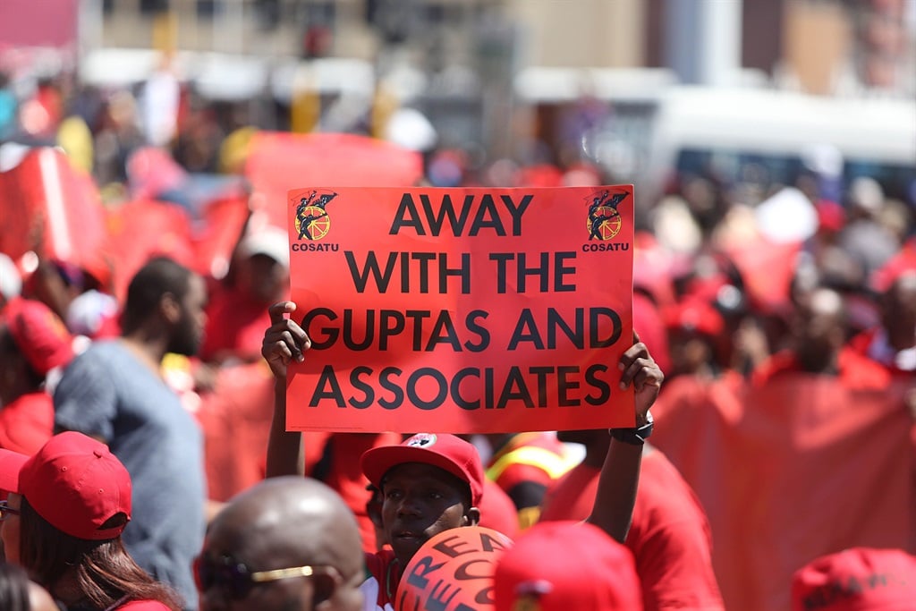 A Cosatu member holds a placard in march against corruption and state capture in September 2017 in Durban.
