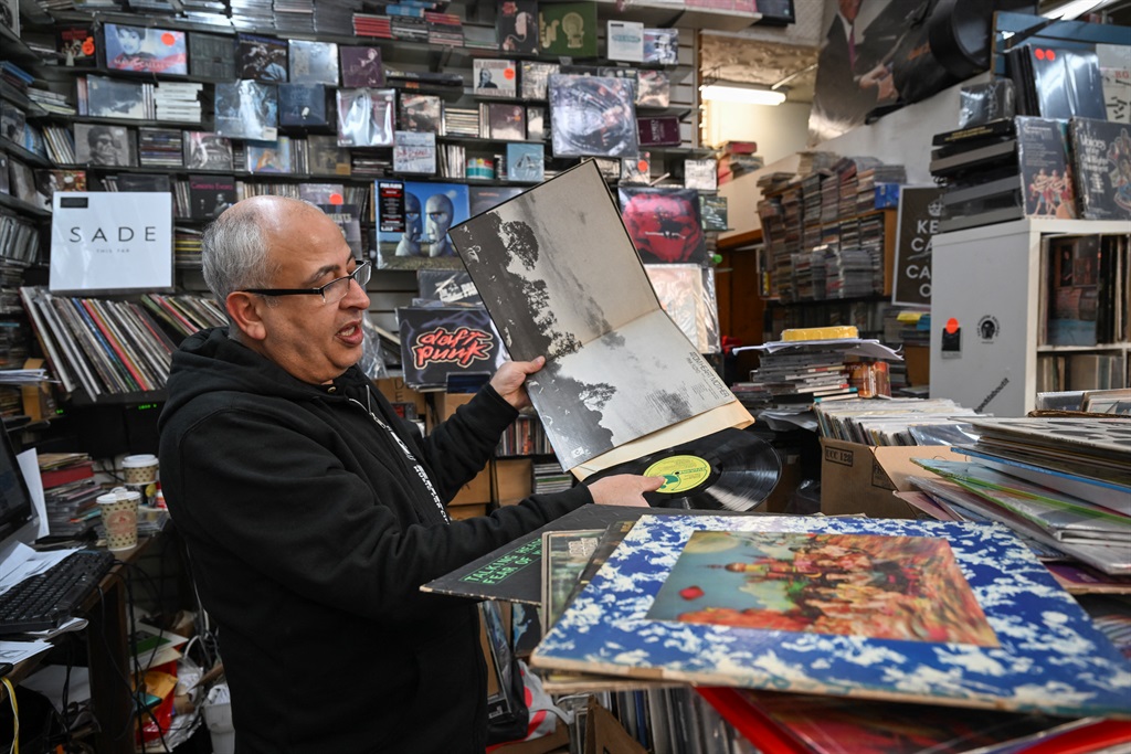 Store owner Jamal Alnasr holds a Pink Floyd record