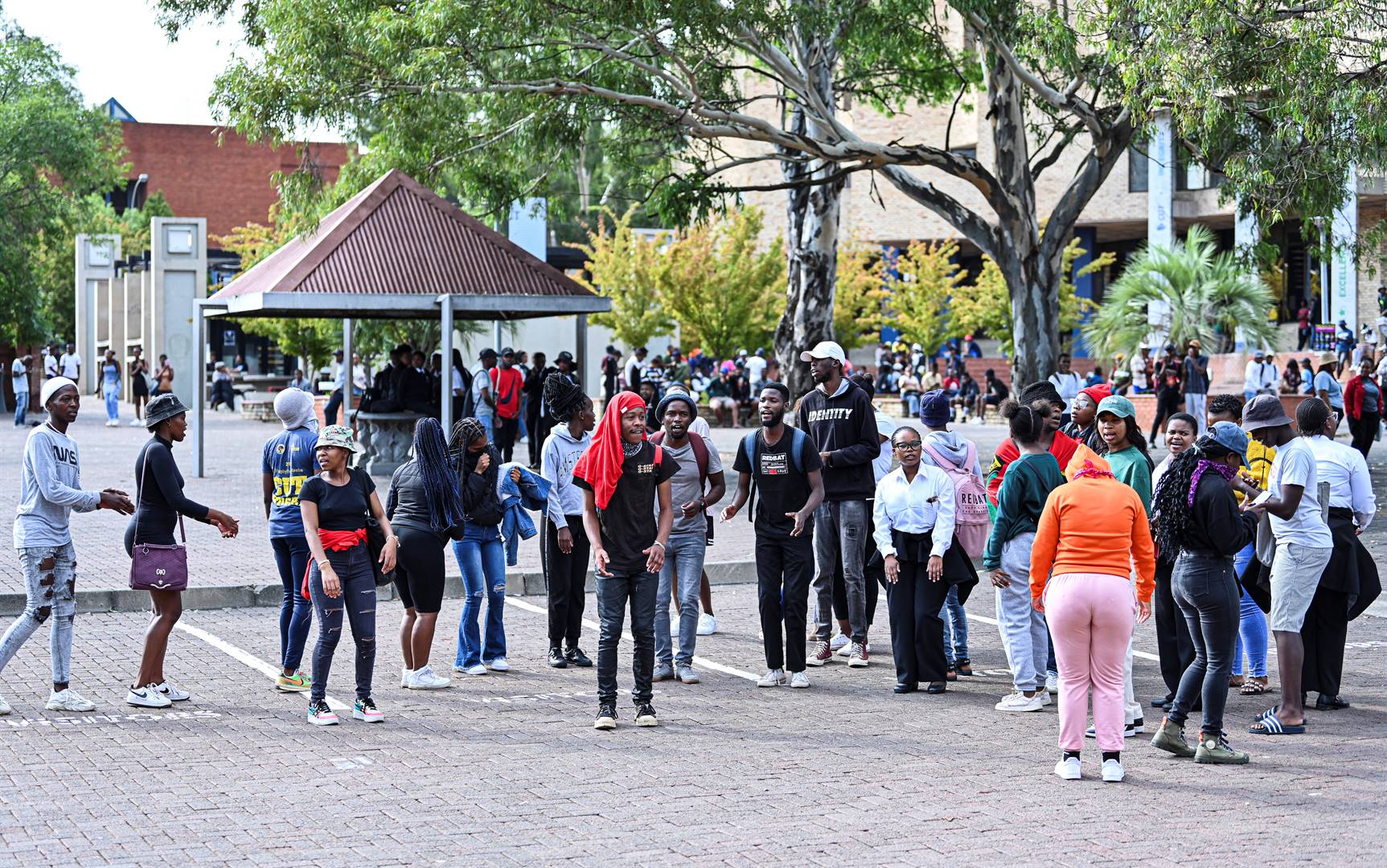 Betogende studente van die Sentrale Universiteit van Tegnologie (SUT) in Bloemfontein drom Vrydagoggend saam voor die universiteit se hoofhek. Foto: Mlungisi Louw