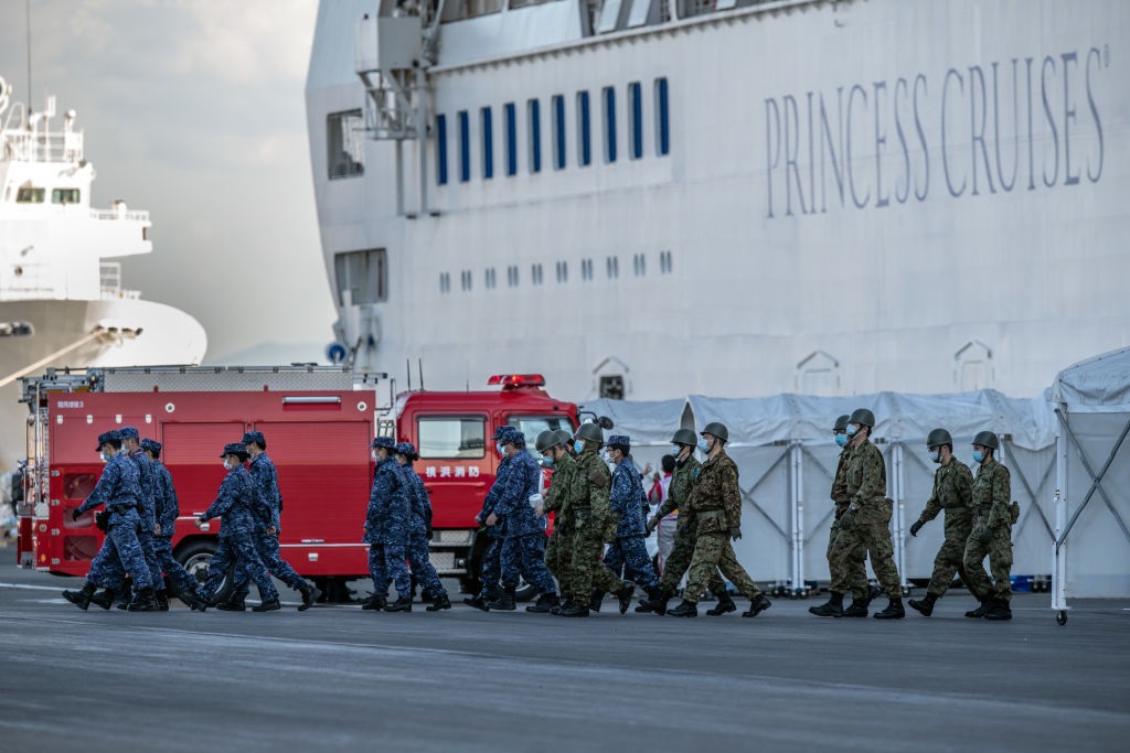اعضای نیروهای دفاع شخصی ژاپن (SDF) از یک کشتی تفریحی قرنطینه در اسکله دایکو در یوکوهاما، ژاپن، جایی که در 10 فوریه 2020 در حال سوخت‌گیری بود، پیاده می‌شوند. (کارل کورت/گتی ایماژ)