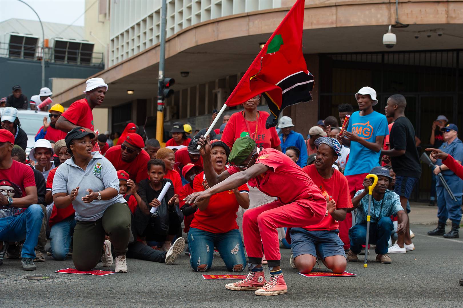 ’n EFF-lid haal sy passies uit terwyl optoggangers op hul knieë in die middestad gestaan en sing het. Foto: Anena Burger