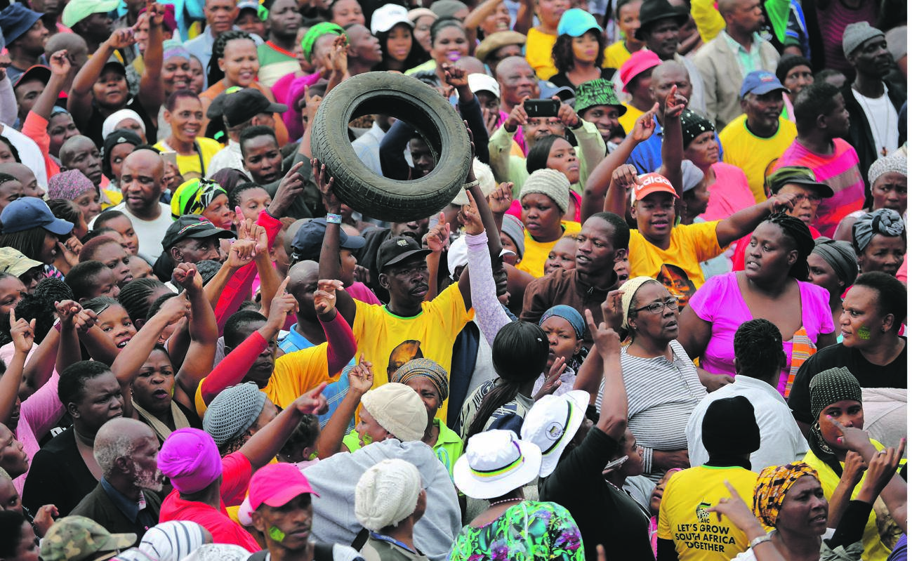 A man holds up a tyre as Alexandra residents gather to listen to President Cyril Ramaphosa on Thursday Picture: Sumaya Hisham / REUTERS
