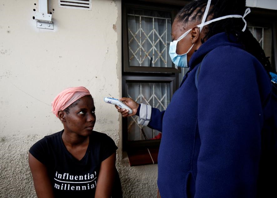 A health worker checks a woman's temperature during a door-to-door testing in an attempt to contain the Covid-19 coronavirus outbreak, in Umlazi township near Durban. Picture: Rogan Ward/Reuters