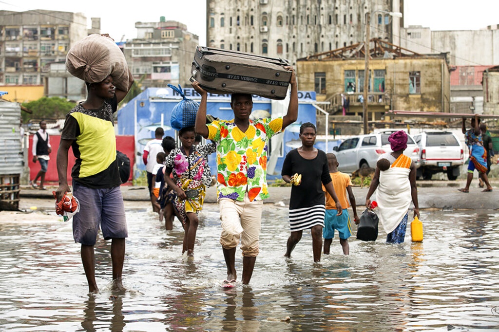 People carry their personal effects after Tropical Cyclone Idai, in Beira, Mozambique. (Denis Onyodi, IFRC via AP)