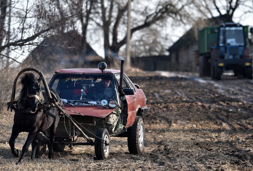 Farmer Alexei Usikov, 31, rides his horse-pulled cart made from an old Audi 80 car in the village of Knyazhitsy, some 230 km east of Minsk, on March 18, 2019. Image: Sergei GAPON / AFP