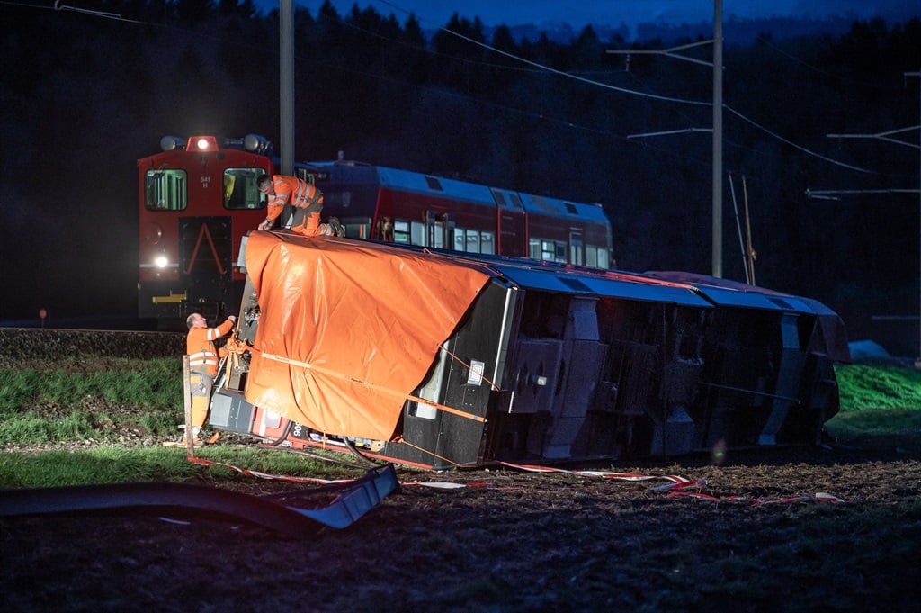 Train staffs work at the site of a train derailment near lakeside town of Luscherz, northwest of the capital Bern. (Photo: Fabrice COFFRINI / AFP)