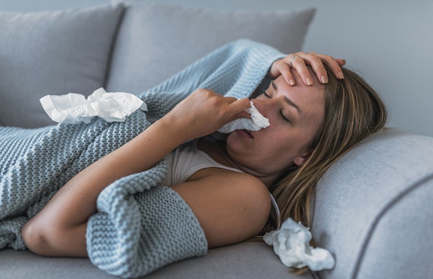 sick woman with nasal congestion on couch 