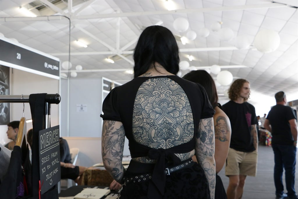 An attendee's intricate back tattoo by artist Chris Devil (@chrisdeviltattoos) is visible through an open-back top at the South African International Tattoo Convention 2023. (Photo: Herman Eloff/News24)