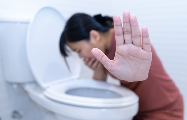 Woman vomiting in toilet