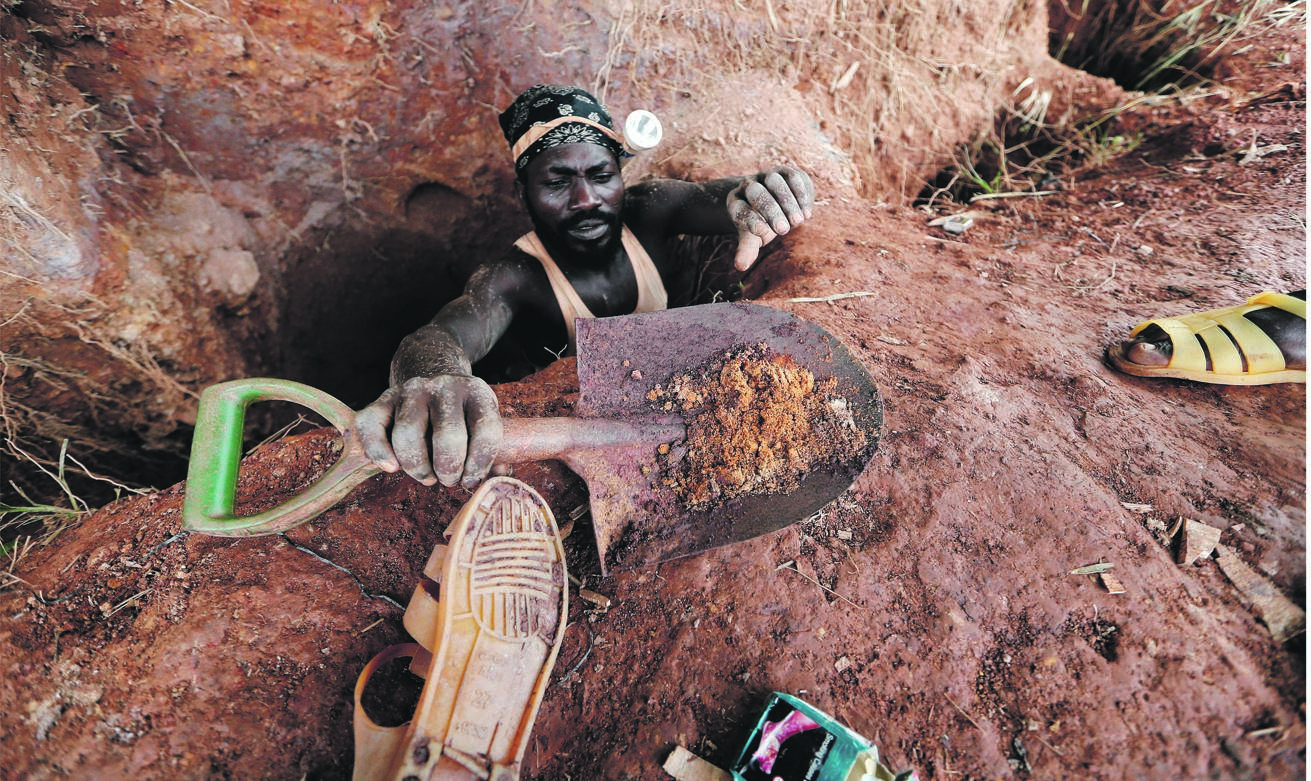 An informal gold miner carries his spade as he climbs out of a gold mining pit at the site of Nsuaem-Top, Ghana. Picture: Zohra Bensemra / reuters 