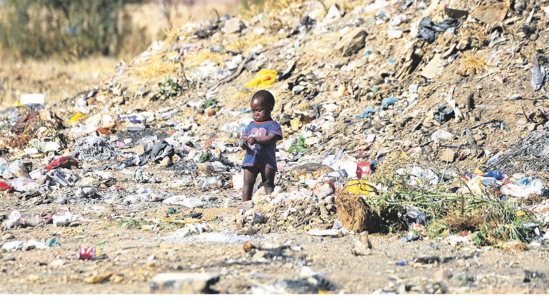 Oblivious kids don’t know the danger of playing in a rubbish dump. Picture: Denvor De Wee