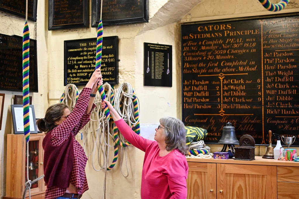 Kate Flavell (R) teaches Anne Porter (L) during a bell ringing training session at All Saints Church, Kingston-upon-Thames, in southwest London, on March 25, 2023. At the top of 52 steep, narrow stone steps at All Saints' church near London, expert bell ringers are putting two new recruits through their paces ahead of King Charles III's coronation. The novices are just two of over 1,000 people who had their interest piqued by the appeal for new recruits by the UK's Central Council of Church Bell Ringers.