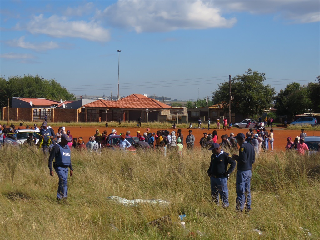 Police and residents at the scene where the body of Fezile Limako was found. Photo by Ntebatse Masipa