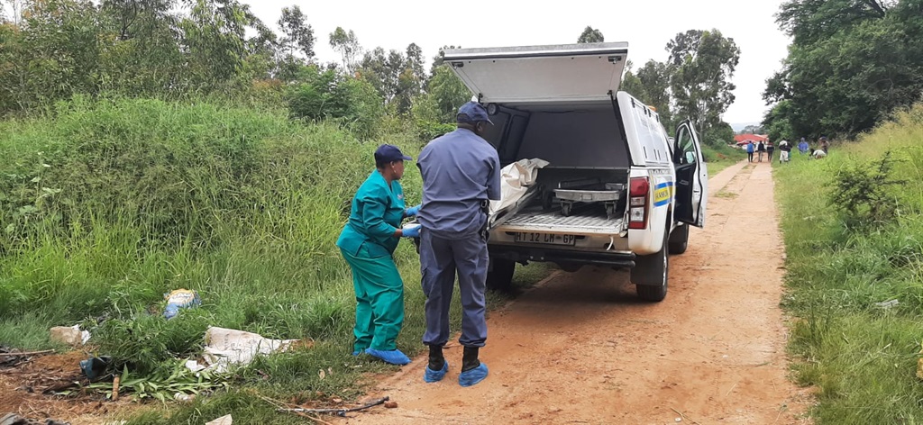Forensic pathology workers loading the man's body into a mortuary van. 