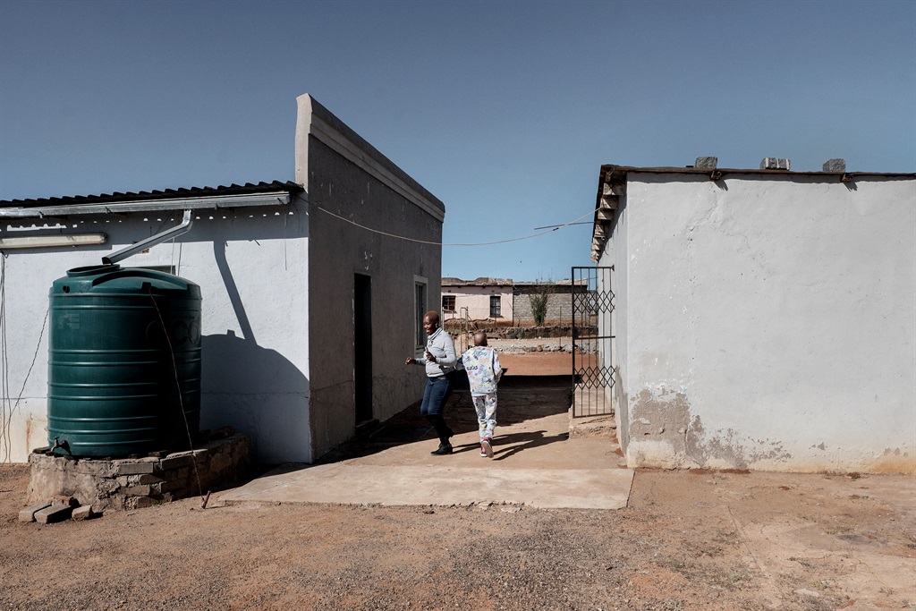 Oratile Diloane (R), 12, and his mother Refilwe Diloane (L), 46, play in the courtyard of their house.
