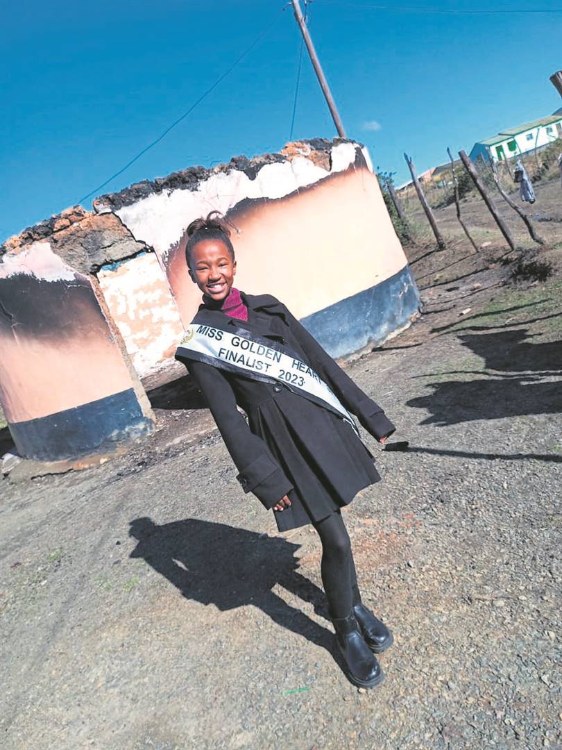Alupheli Mxotwa posing in front of the rondavel which was destroyed by fire.                    