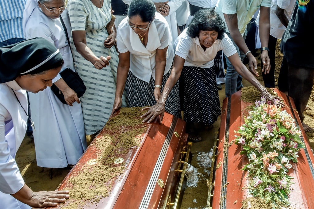 Relatives of the dead offer their prayers during funerals in Katuwapity village on April 23, 2019 in Negambo, Sri Lanka. At least 311 people were killed with hundreds more injured after coordinated attacks on churches and hotels on Easter Sunday rocked three churches and three luxury hotels in and around Colombo as well as at Batticaloa in Sri Lanka. Sri Lankan authorities declared a state of emergency on Monday as police arrested 24 people so far in connection with the suicide bombs, which injured at least 500 people as the blasts took place at churches in Colombo city as well as neighboring towns and hotels, including the Shangri-La, Kingsbury and Cinnamon Grand. (Photo by Atul Loke/Getty Images)