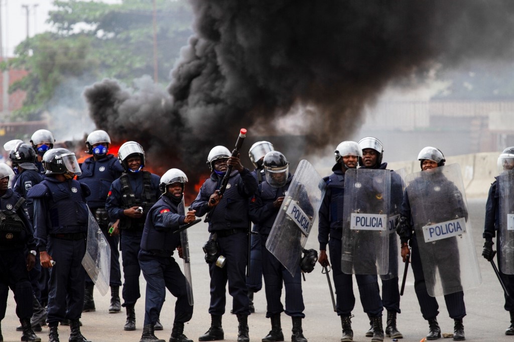 A Police officer prepares to fire teargas towards protesters during a anti-government demonstration in Luanda.