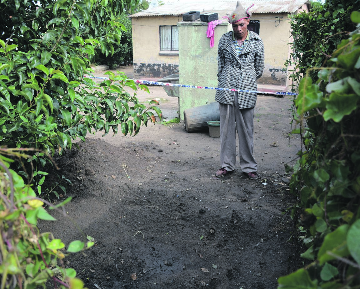 Siyabonga Kubheka stands near the spot where a body was found in a shallow grave.     Photo by    Muntu Nkosi
