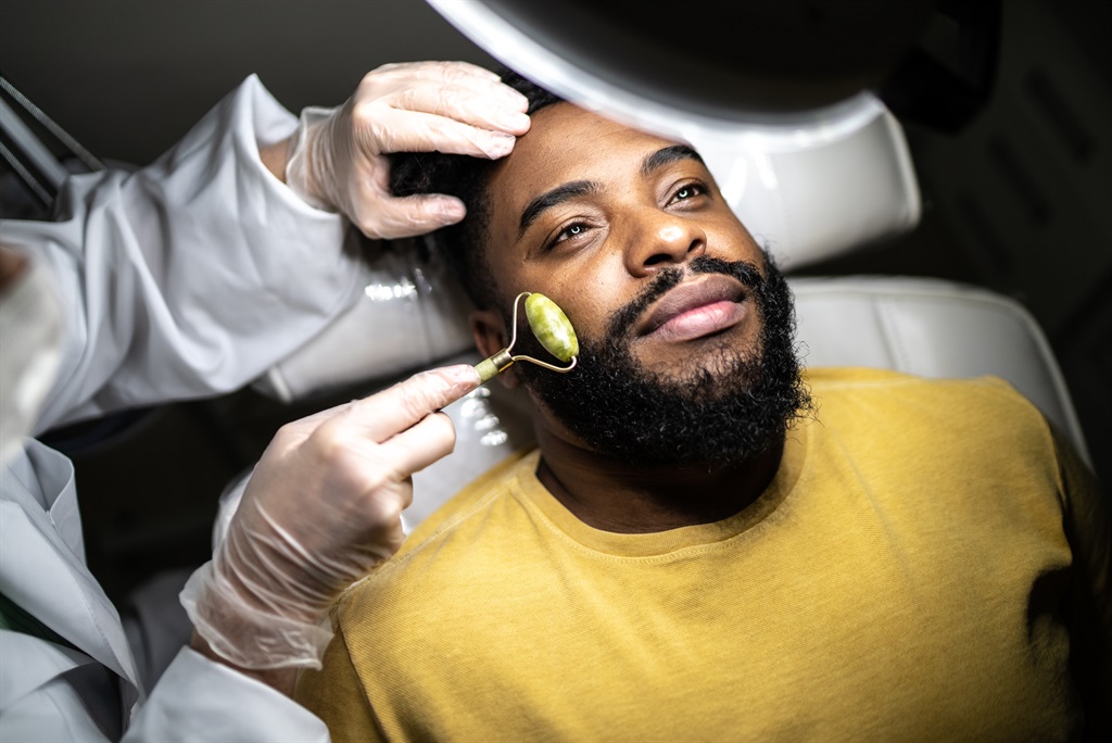 Mid adult man receiving a facial massage at a spa