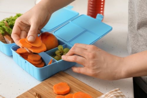 Hands packing a healthy lunchbox