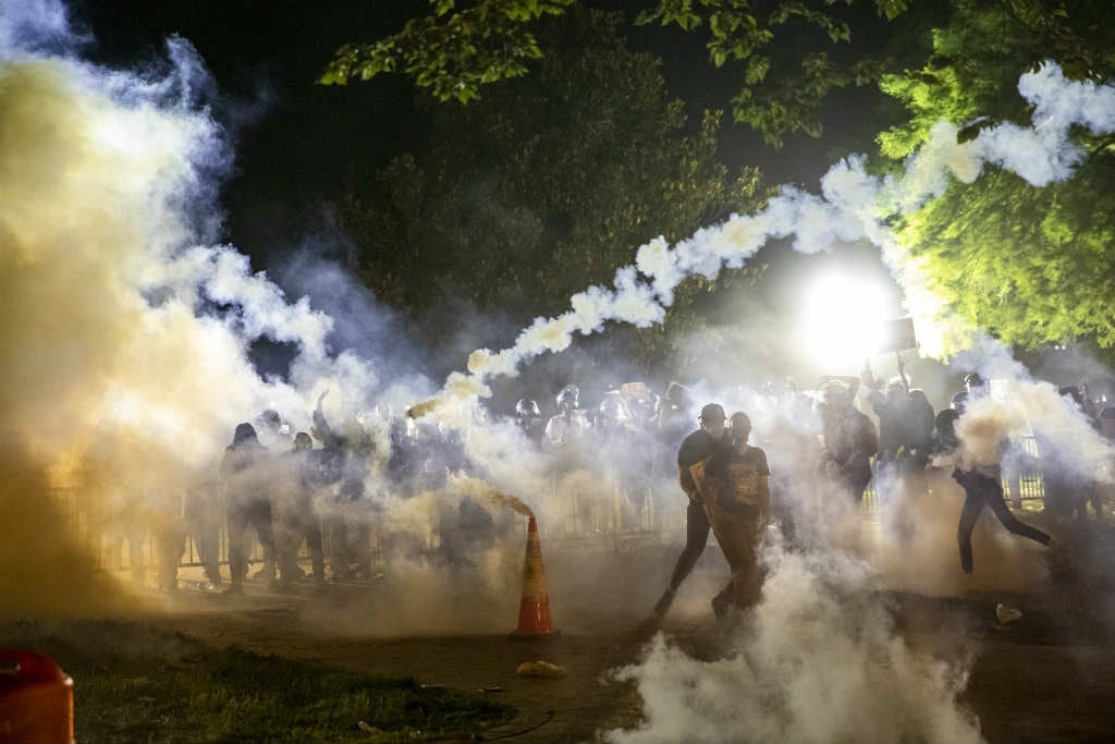 Tear gas rises above as protesters face off with p