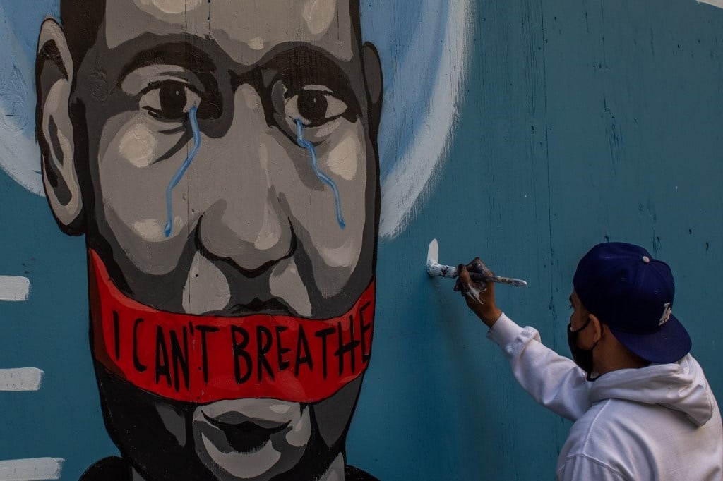 The artist Celos paints a mural in Downtown Los Angeles on May 30, 2020 in protest against the death of George Floyd, an unarmed black man who died while while being arrested and pinned to the ground by the knee of a Minneapolis police officer. 
