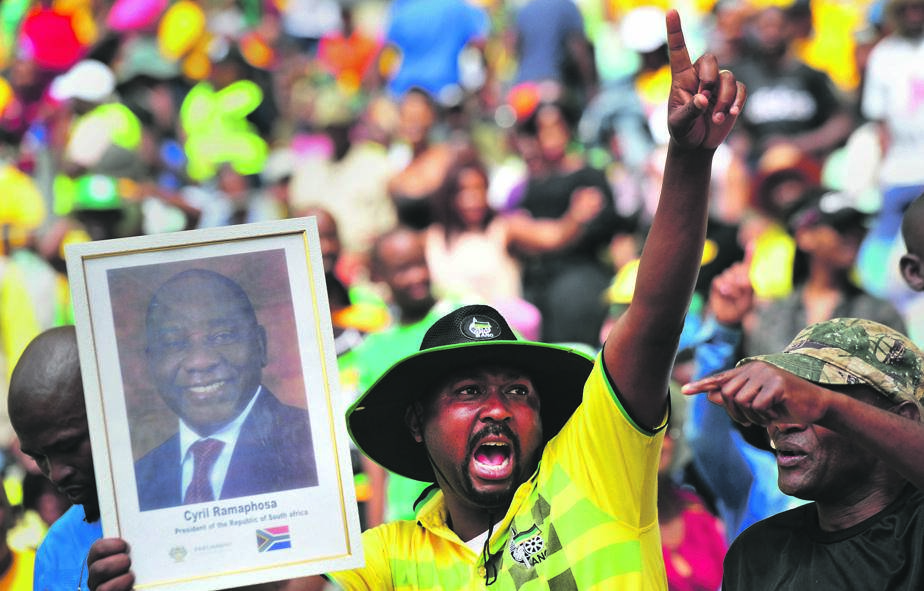 An ANC supporter in party regalia holds up a poster  branded with President Cyril Ramaphosa’s face during the party’s manifesto launch at Moses Mabhida Stadium in Durban Picture: Leon Sadiki