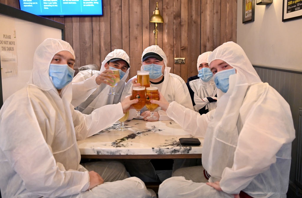 Customers wearing protective clothing and face masks enjoy a drink at the Wellington Pub in Borehamwood, England. 